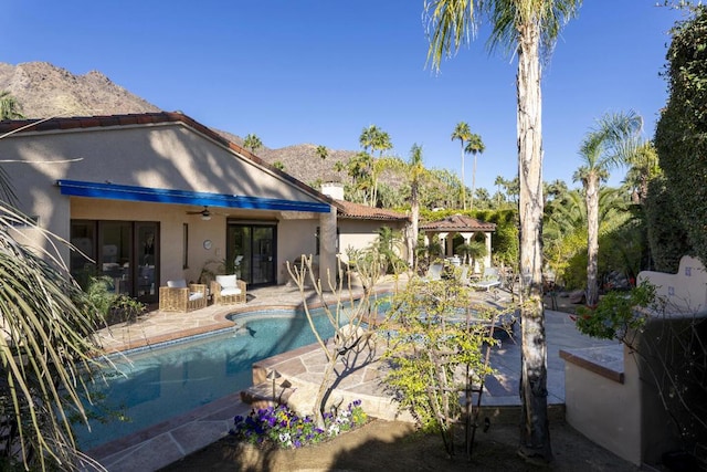 view of pool with ceiling fan, a mountain view, and a patio area