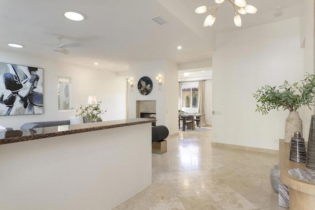 interior space featuring ceiling fan with notable chandelier