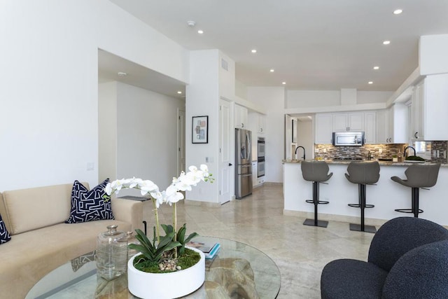 living room with lofted ceiling and sink