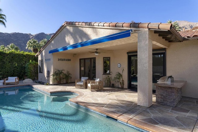 view of pool with a mountain view, a patio, and ceiling fan