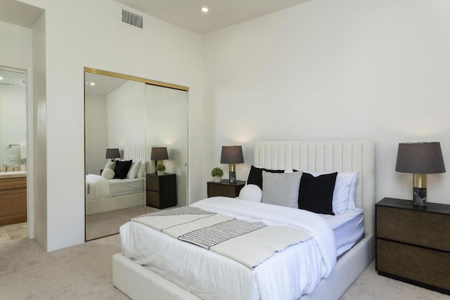 carpeted bedroom featuring ensuite bath and a closet