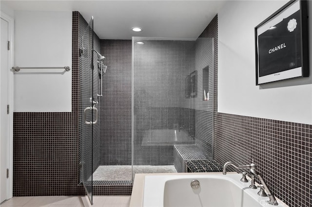 bathroom with tile walls, tile patterned flooring, and independent shower and bath