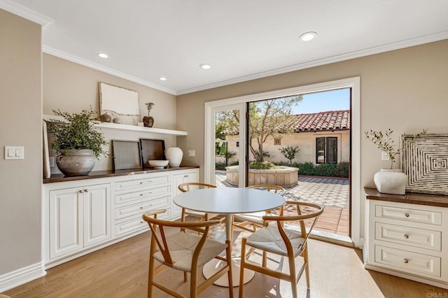 dining area with light wood-style floors, recessed lighting, and ornamental molding