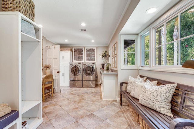 washroom featuring visible vents, ornamental molding, cabinet space, and washer and dryer