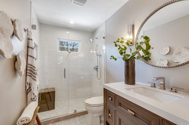 bathroom with a stall shower, visible vents, vanity, and toilet