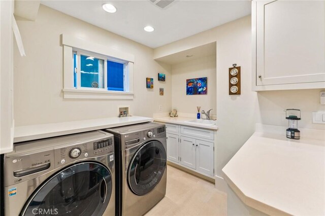 laundry area with cabinets, sink, and washing machine and dryer