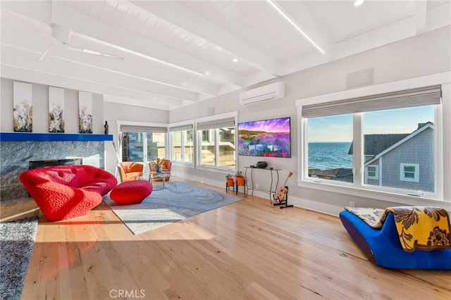 living room featuring baseboards, hardwood / wood-style floors, an AC wall unit, a fireplace, and beam ceiling