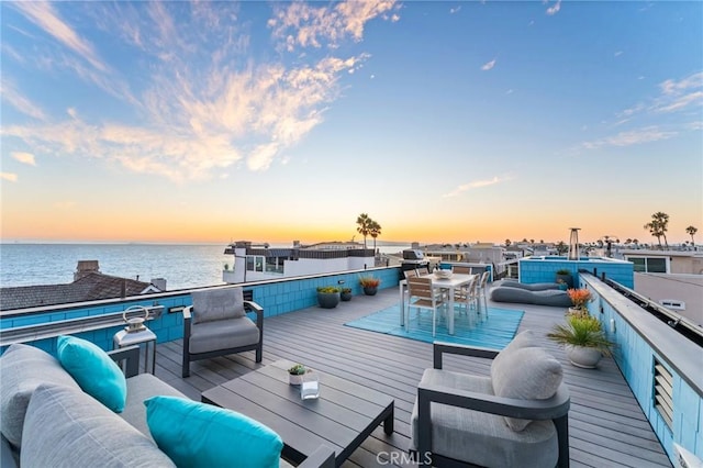 wooden deck with a water view and outdoor lounge area