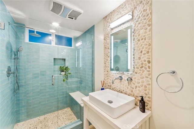 full bathroom featuring visible vents, a shower stall, and vanity