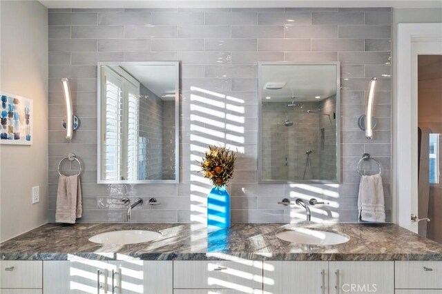 bathroom featuring tasteful backsplash, vanity, and walk in shower