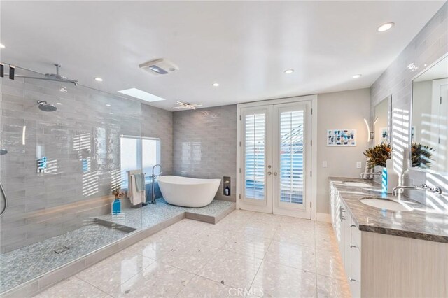 bathroom featuring french doors, vanity, tile patterned flooring, and plus walk in shower