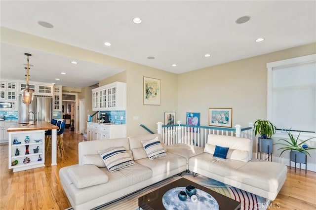 living area with light wood-type flooring and recessed lighting