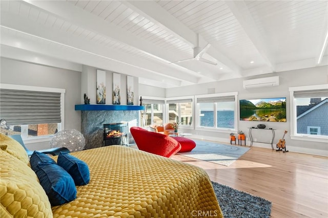 bedroom with a multi sided fireplace, beamed ceiling, wood-type flooring, ceiling fan, and a wall unit AC