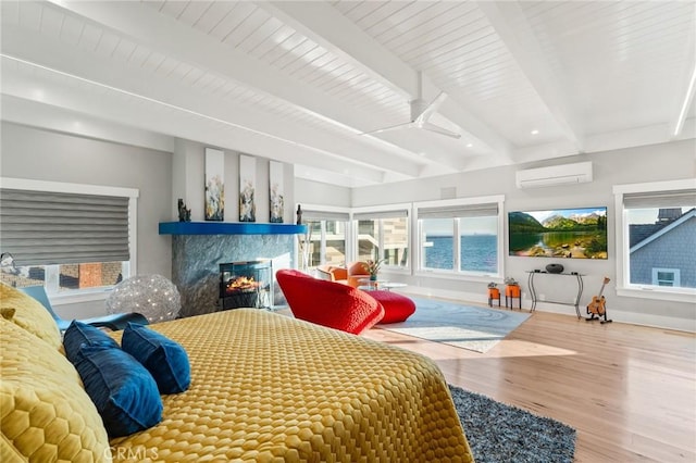 bedroom with a wall unit AC, wood finished floors, a multi sided fireplace, baseboards, and beamed ceiling