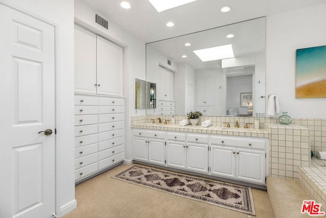 bathroom featuring a skylight and vanity