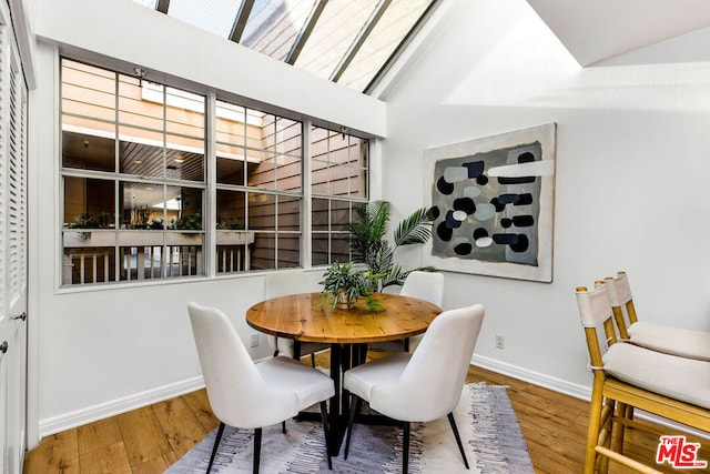 dining area with vaulted ceiling and wood-type flooring