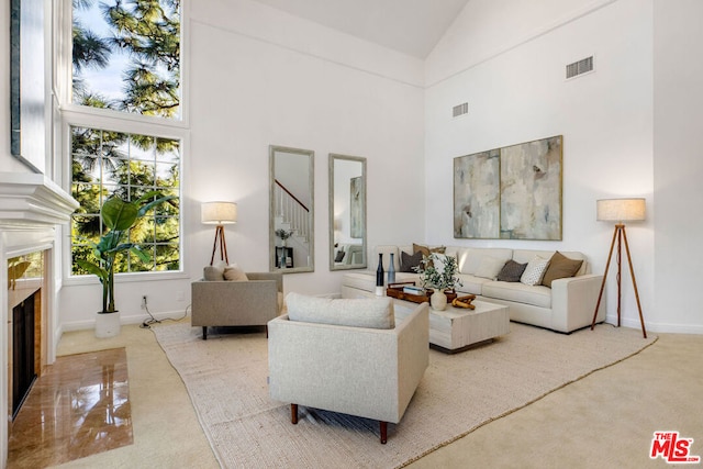 living room with high vaulted ceiling, carpet, and a fireplace