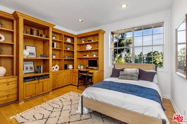 bedroom featuring light wood-type flooring and built in desk