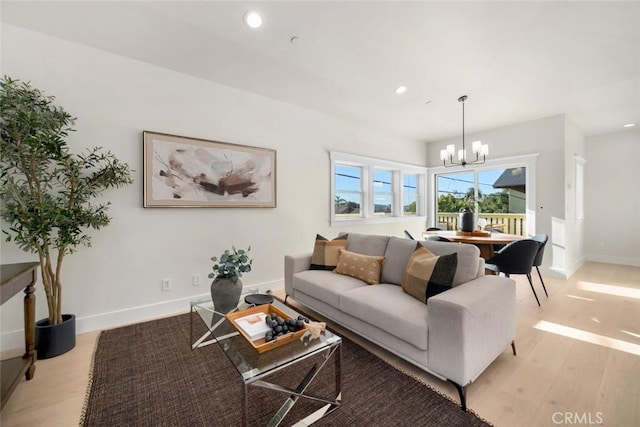 living room with a notable chandelier and light hardwood / wood-style flooring