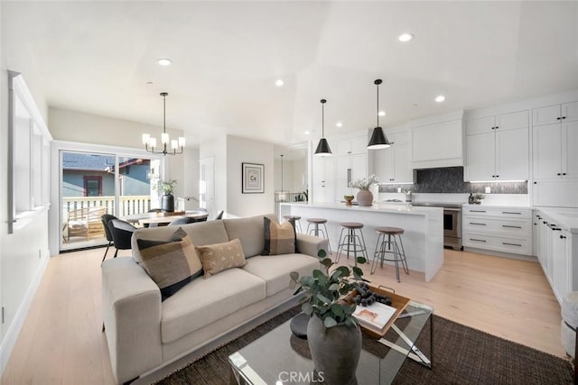 living room with an inviting chandelier and light wood-type flooring