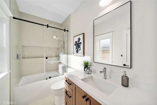 full bathroom with tiled shower / bath combo, vanity, and toilet