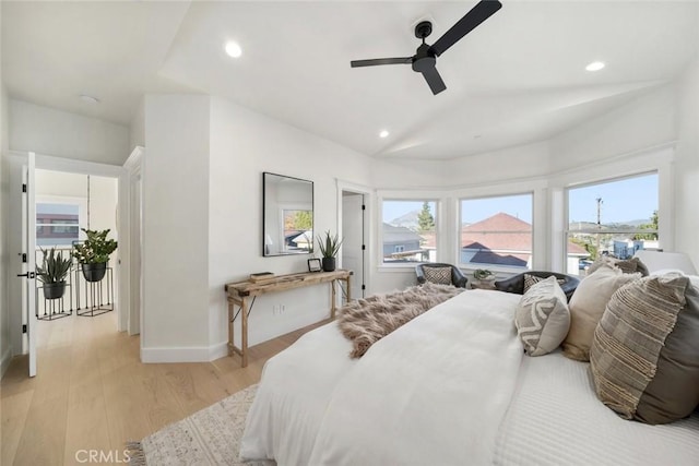 bedroom with ceiling fan, vaulted ceiling, and light hardwood / wood-style floors