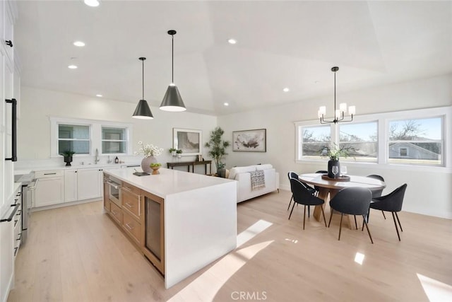 kitchen with a center island, light countertops, light wood-style floors, white cabinetry, and recessed lighting