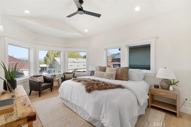 bedroom with light wood-type flooring, vaulted ceiling, and ceiling fan