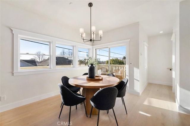 dining area featuring light hardwood / wood-style floors and a notable chandelier