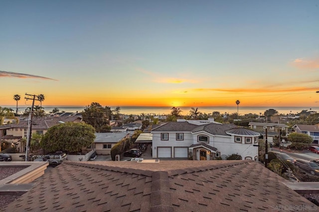 aerial view at dusk featuring a water view