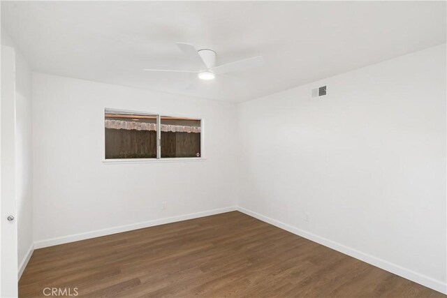 empty room with ceiling fan and dark hardwood / wood-style flooring