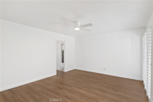 empty room with ceiling fan and dark hardwood / wood-style floors