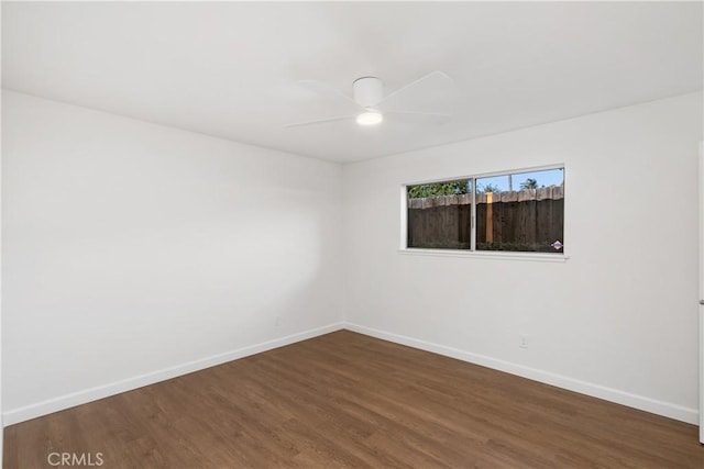 empty room with ceiling fan and dark hardwood / wood-style flooring