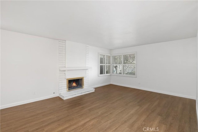 unfurnished living room featuring dark hardwood / wood-style flooring and a fireplace