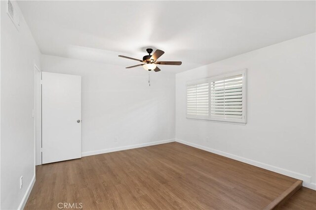 empty room with ceiling fan and wood-type flooring