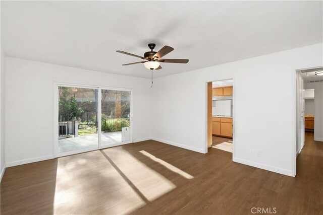 unfurnished room with ceiling fan and dark wood-type flooring