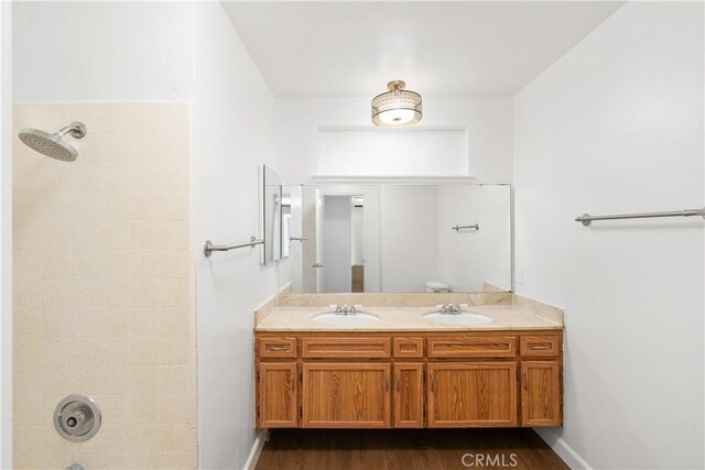 bathroom featuring tiled shower / bath combo, wood-type flooring, and vanity