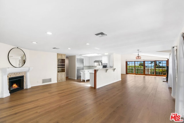 unfurnished living room featuring dark hardwood / wood-style flooring and a tile fireplace