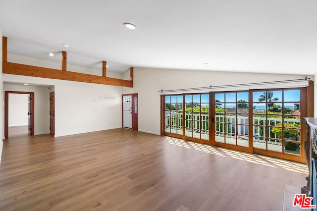 empty room with vaulted ceiling and wood-type flooring