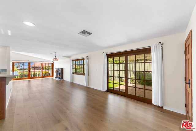 unfurnished living room featuring lofted ceiling and light hardwood / wood-style floors