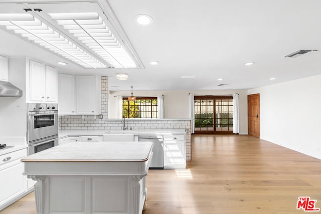 kitchen with stainless steel appliances, white cabinetry, and a kitchen island