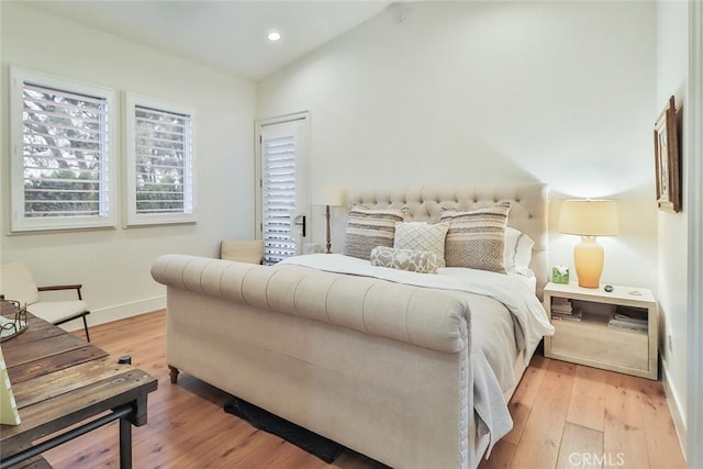 bedroom featuring lofted ceiling and light hardwood / wood-style floors