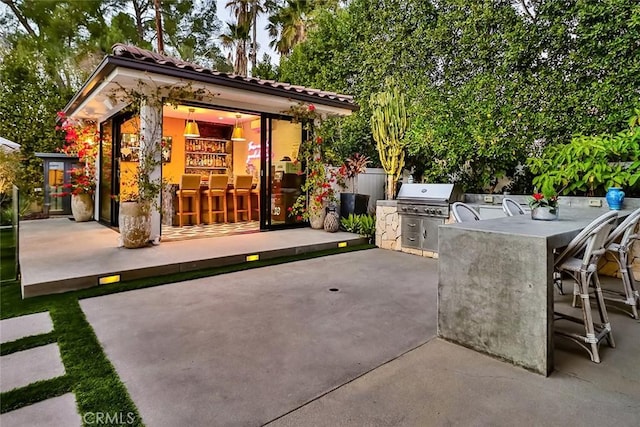 view of patio / terrace with grilling area, an outdoor kitchen, and a bar