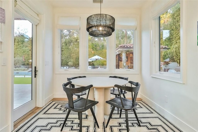 sunroom / solarium featuring an inviting chandelier