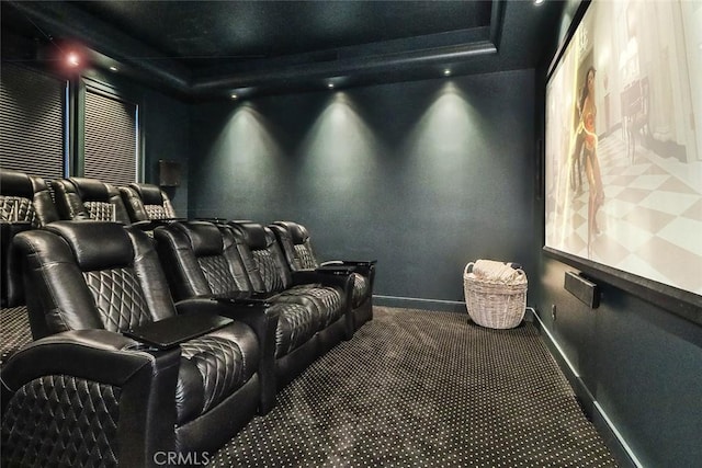 carpeted home theater room featuring a raised ceiling