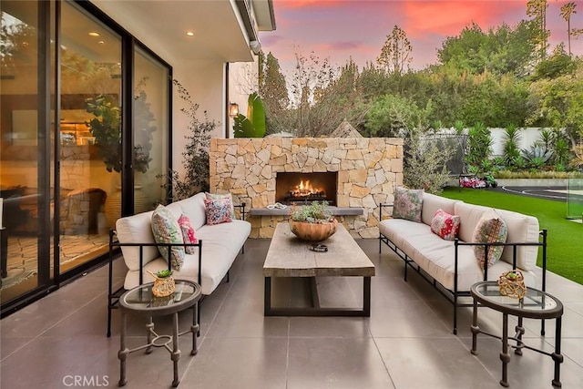 patio terrace at dusk with an outdoor living space with a fireplace