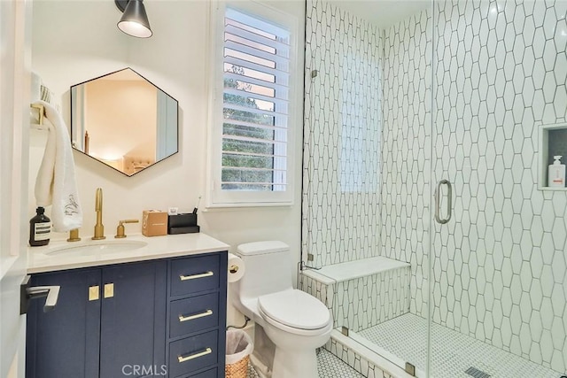 bathroom featuring toilet, tile patterned flooring, an enclosed shower, and vanity