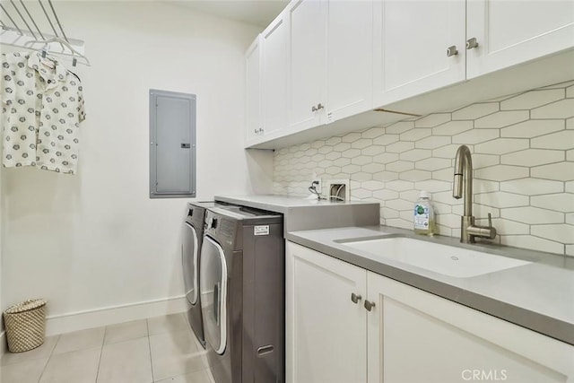 washroom with independent washer and dryer, electric panel, light tile patterned flooring, sink, and cabinets