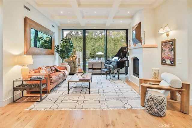 interior space featuring beamed ceiling, coffered ceiling, floor to ceiling windows, and light hardwood / wood-style floors