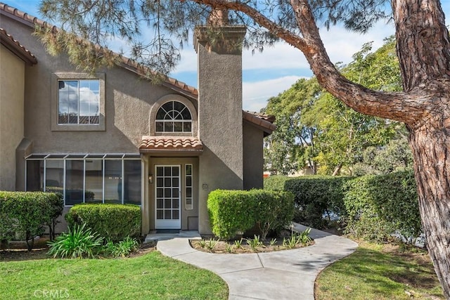 property entrance with a lawn